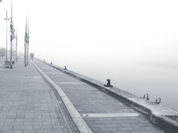 Man walking on shore against clear sky