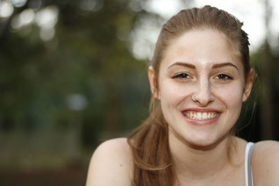 Close-up portrait of smiling beautiful woman at park