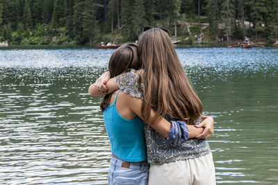 Rear view of women standing in lake