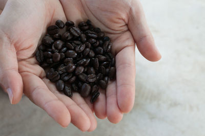 Cropped hands holding roasted coffee beans