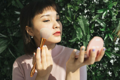 Portrait of woman holding plant