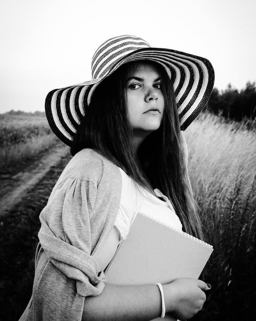 hat, clothing, one person, lifestyles, real people, leisure activity, young adult, portrait, women, looking away, young women, sky, field, waist up, focus on foreground, long hair, casual clothing, land, nature, hairstyle, hair, beautiful woman, outdoors, contemplation