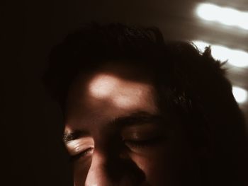 Close-up portrait of young man against black background