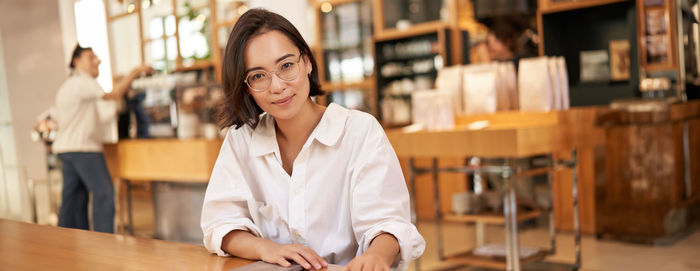 Portrait of young woman sitting in library