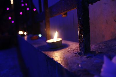 Close-up of illuminated lamp on retaining wall at night