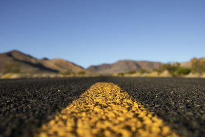 Landscape showing some mountains under a blue sky viewed from the asphalt of a road in california