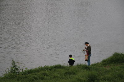 Rear view of friends and son in water