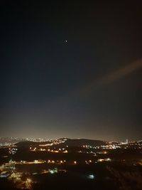 Illuminated cityscape against sky at night