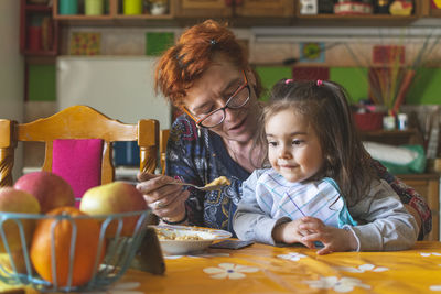 Portrait of mother and daughter on table