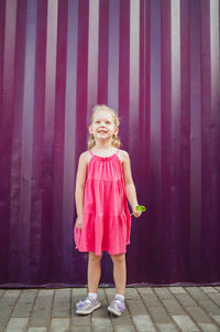Portrait of girl standing against yellow wall