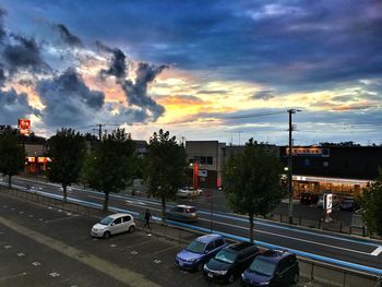 Traffic on road against cloudy sky