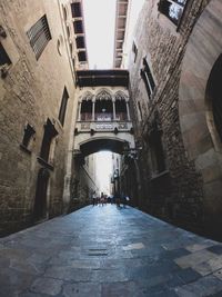 People walking in alley amidst buildings in city