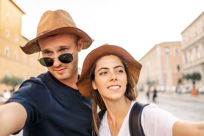 Portrait of young woman wearing sunglasses while standing in city