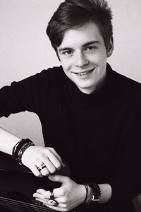 Portrait of handsome young man with guitar against white background