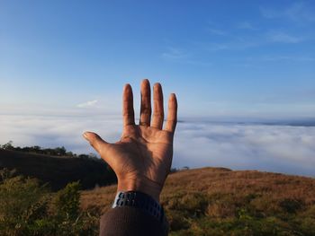 Midsection of person with arms raised against sky