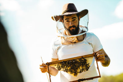 Portrait of man with honey bees outdoors