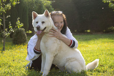 Portrait of senior woman with dog on field