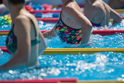 Midsection of people in swimming pool