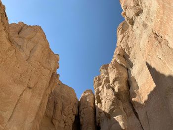 Low angle view of rock formation against clear blue sky