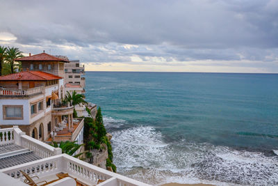 Scenic view of sea by buildings against sky