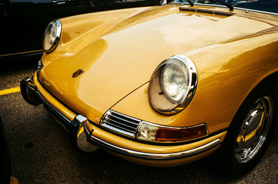 Close-up of yellow car on street