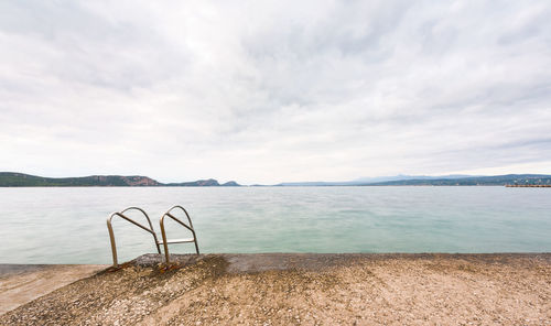 Overcast seascape from a jetty with swimming pool ladder plungeing in to the sea in pylos, greece