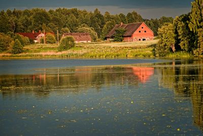 Scenic view of lake by building and trees