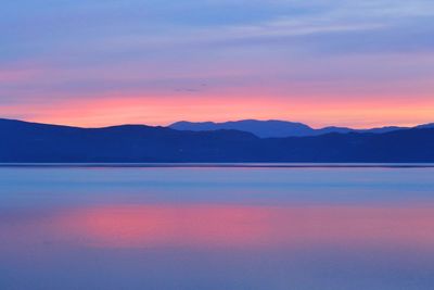 Scenic view of lake against romantic sky at sunset