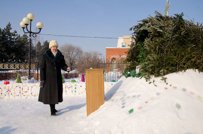 Woman standing on snow covered tree