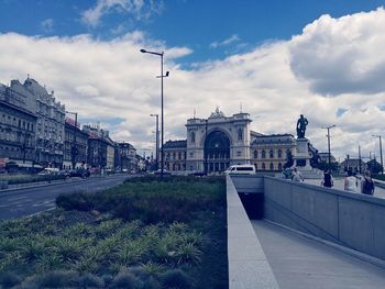 View of buildings in city against cloudy sky