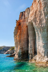 Rock formation in sea against sky