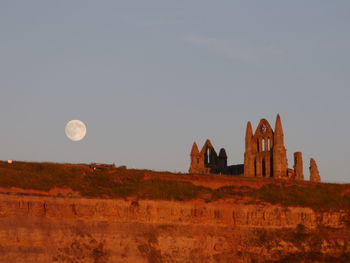 Low angle view of whitby abbey against clear sky at dusk
