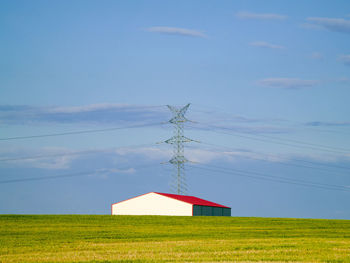 Traditional windmill on field against sky