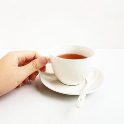 Close-up of hand holding coffee cup