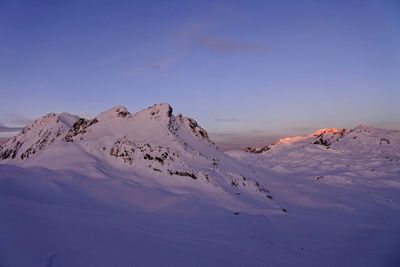 Scenic view of snow mountains against sky during sunset