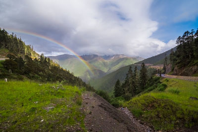 Scenic view of rainbow over mountain against sky