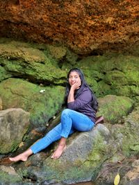 Portrait of woman sitting on rock