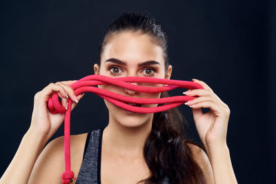 Close-up portrait of beautiful young woman over black background