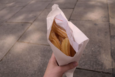Cropped image of hand holding churros