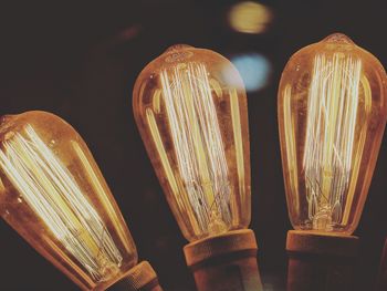 Close-up of illuminated lighting equipment against black background