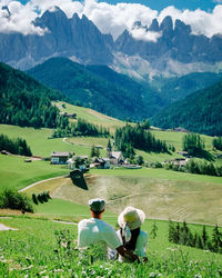 Rear view of couple looking at field against mountains