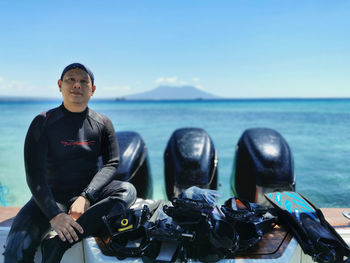 Portrait of me sitting on the boat by sea against sky and mountain