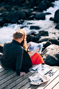 Man and woman sitting on pier