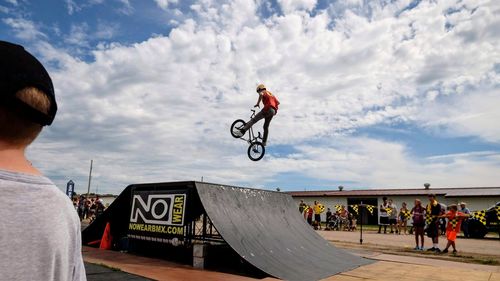 Man and bicycle in mid-air against sky