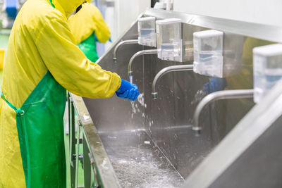 Midsection of woman standing in factory