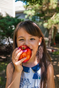 Portrait of girl biting apple