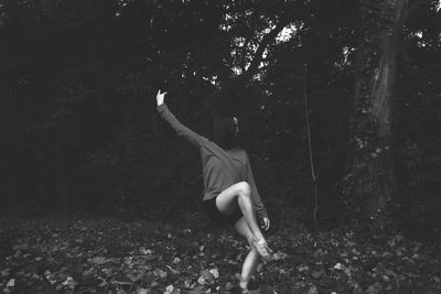 Rear view of woman on field in forest