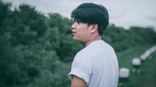 Side view portrait of young man standing on land