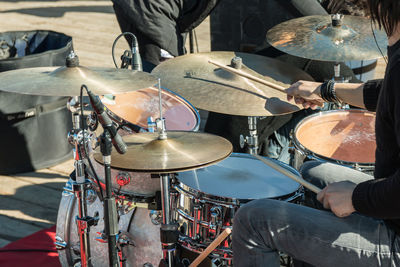Midsection of man playing drums on stage 