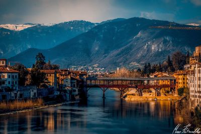 Bridge over river in city against sky